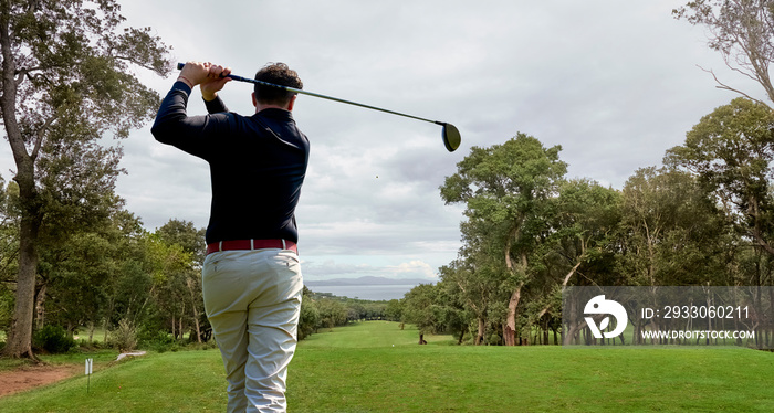 Golfer on the professional golf course. Golfer with golf club hitting the ball for the perfect shot.