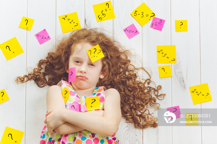 Crying child with question symbol with stickers on his head and around.