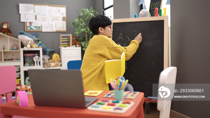 Young chinese woman preschool teacher having online class at kindergarten