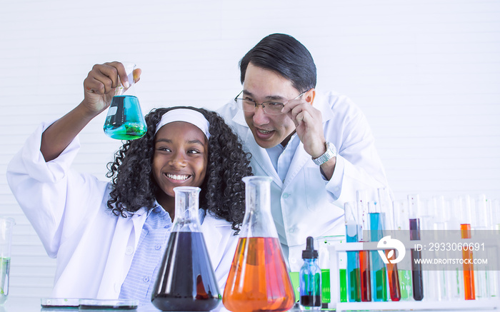 Portrait of asian male teacher and african black  girl studying science in classroom