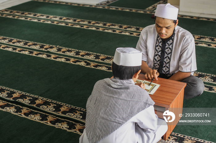 Muslim cleric teaching his students to read the Koran in the mosque