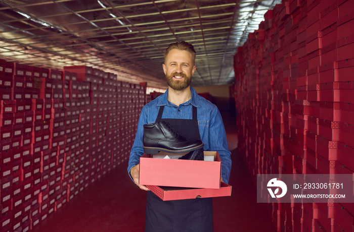 Happy man, businessman, shoe factory director, shoemaker, logistics manager or shop owner, holding red cardboard box with classic black leather boot. Modern footwear manufacturing and business concept