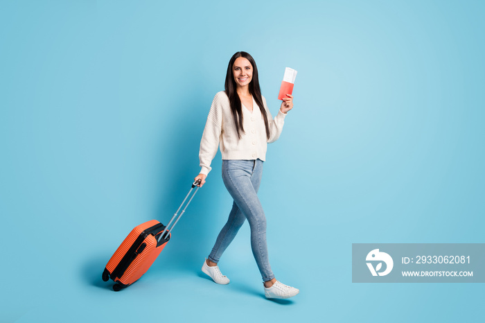 Full body profile portrait of attractive cheerful person arm hold ticket carry bag isolated on blue color background