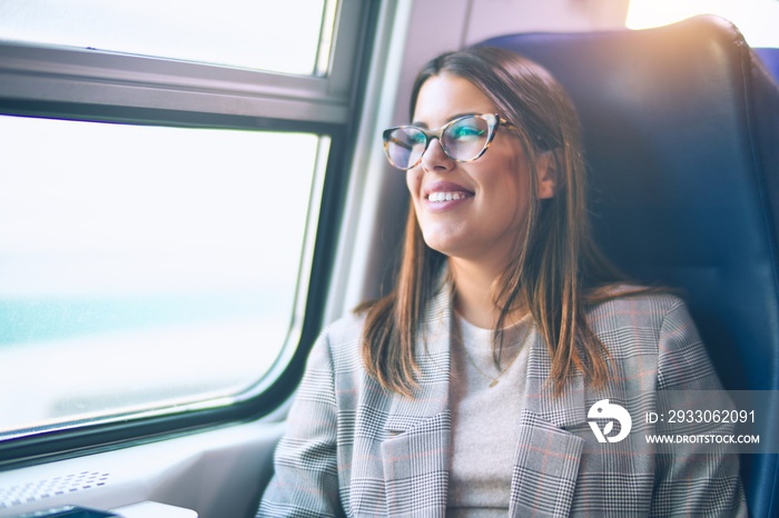 Young beautiful woman smiling happy and confident. Sitting with smile on face travelling by train