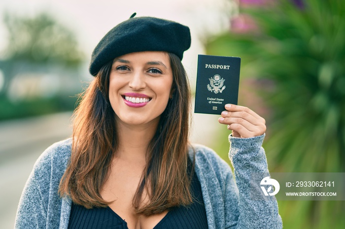 Young latin woman wearing french style holding usa passport at the city.