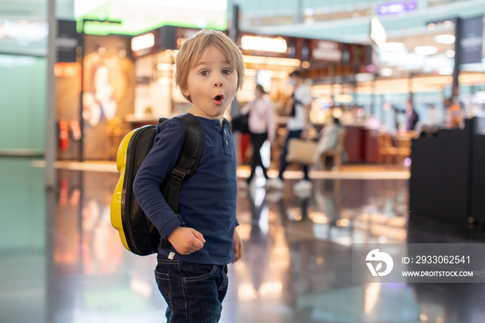 Cute  baby boy waiting boarding to flight in airport transit hall near departure gate. Active family lifestyle travel by air with children