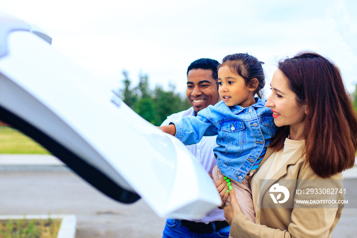 latin hispanic man and beautiful woman with cute daughter ready for trip on car