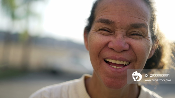 One happy Senior older woman laughing and smiling. Joyful South American Brazilian senior lady closeup face stands outdoors