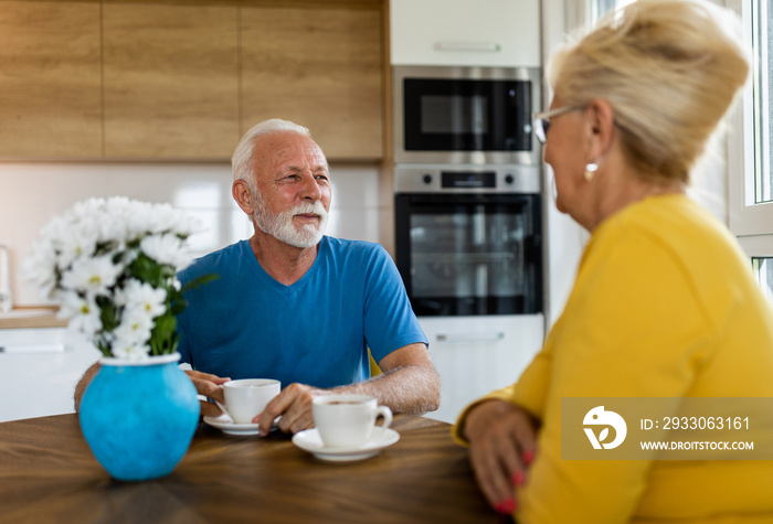 Senior man and woman drinking coffee at home