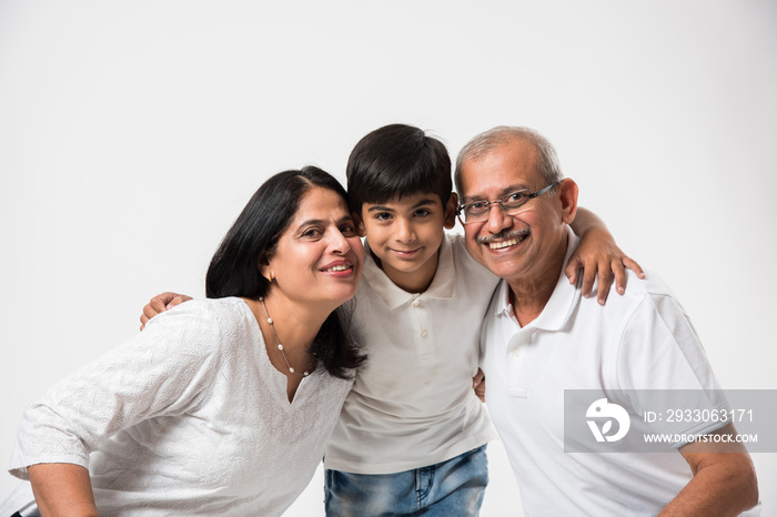 Indian/asian senior couple with grandson, isolated over white