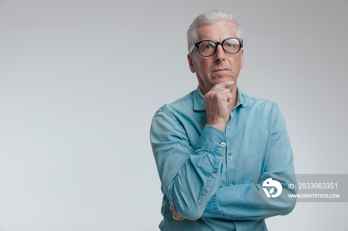 portrait of handsome man in his 60s looking up and thinking