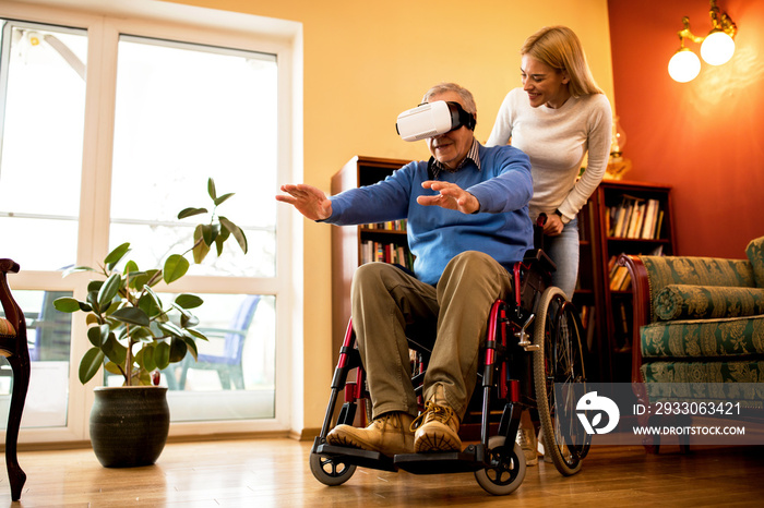 Senior man in wheelchair having fun while using VR