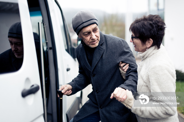 Nurse Helping Senior Man Enter A Van