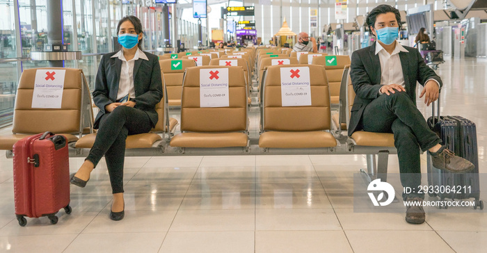 travelers Asian women wearing masks covid 19 disease Prevention An sitting, creating a social distancing while waiting check in with smartphone in the airport terminal