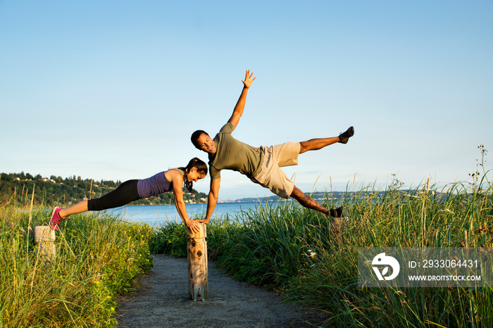 Couple balancing on wooden pillars