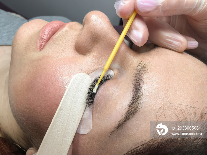 Close-up of the eyelash extension removal procedure. Portrait of a woman in a beauty salon