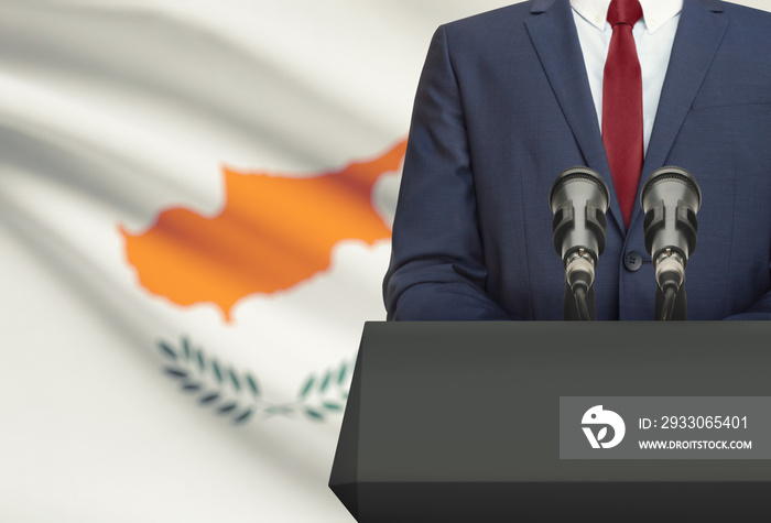 Businessman or politician making speech from behind a pulpit with national flag on background - Cyprus