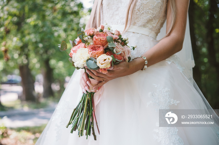 The bridegroom embraces the bride’s waist,