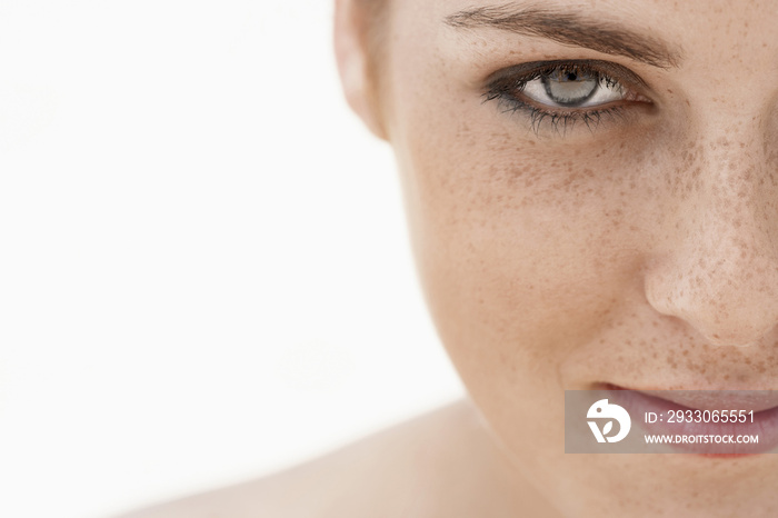 Closeup of teenage girl’s face with freckles isolated over white background