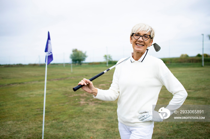 Portrait of senior female golfer enjoying her retirement by playing golf.