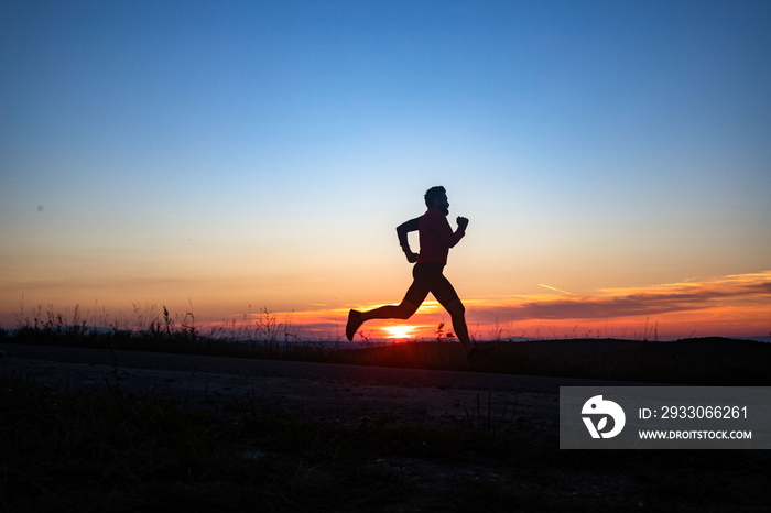 active man silhouette running at sunset