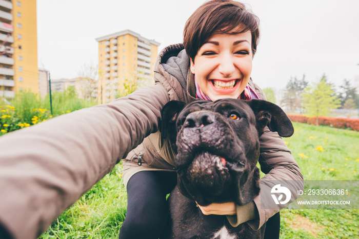 Smiling young woman taking selfie with her dog