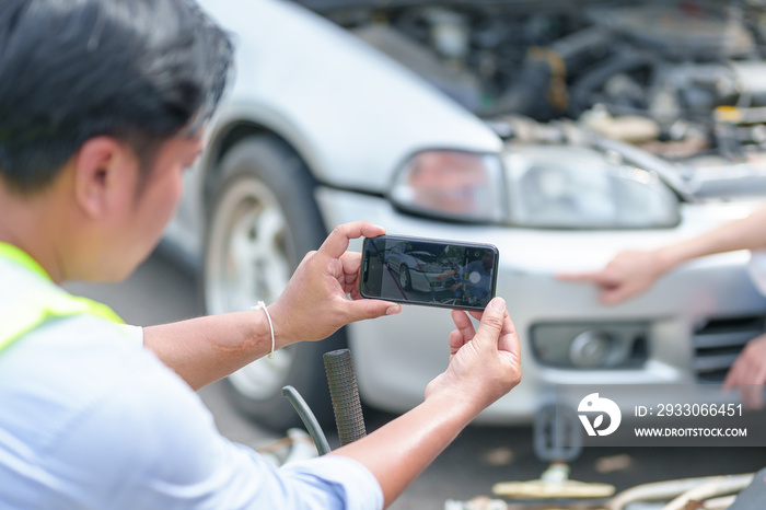 Insurance agent takes pictures of crashed car on his smartphone and fills out the insurance. Insurance agent services concept