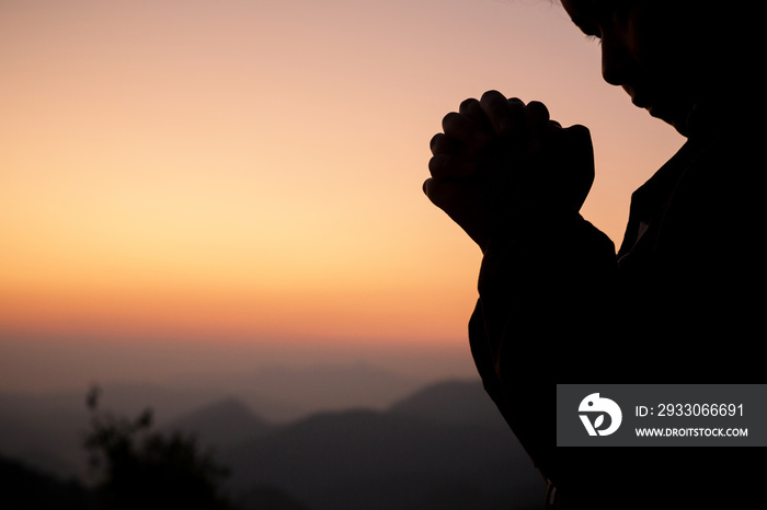 Silhouette of girl praying over beautiful sky background. Christian Religion concept background. fighting and victory for god