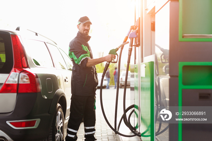 Bearded employee near gas pump