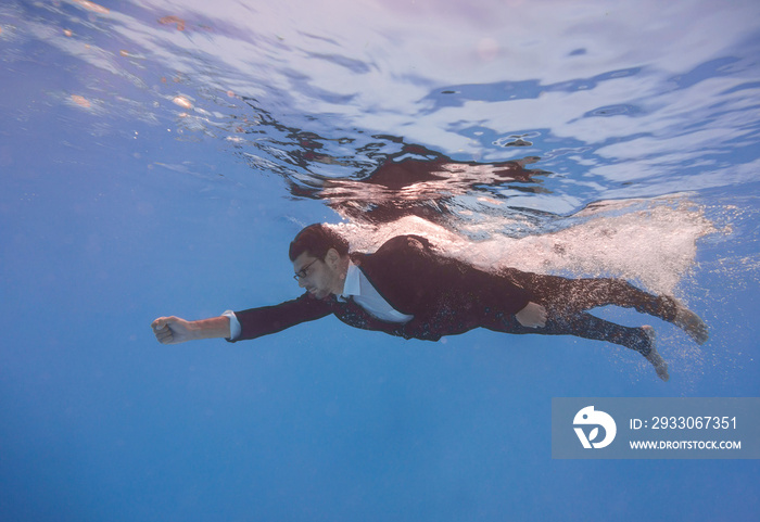 businessman swimming underwater