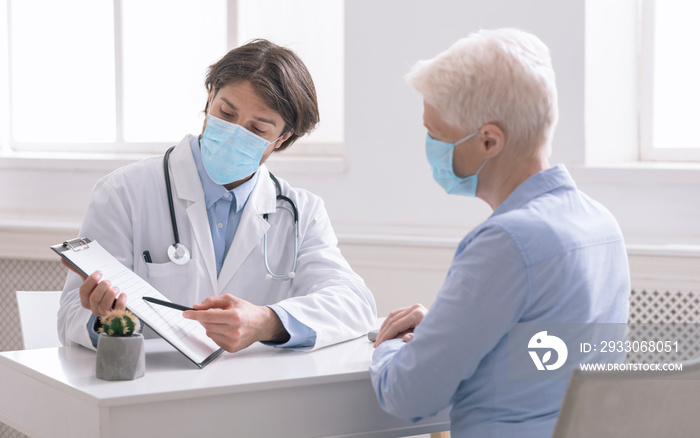 General practitioner showing analysis results to senior woman