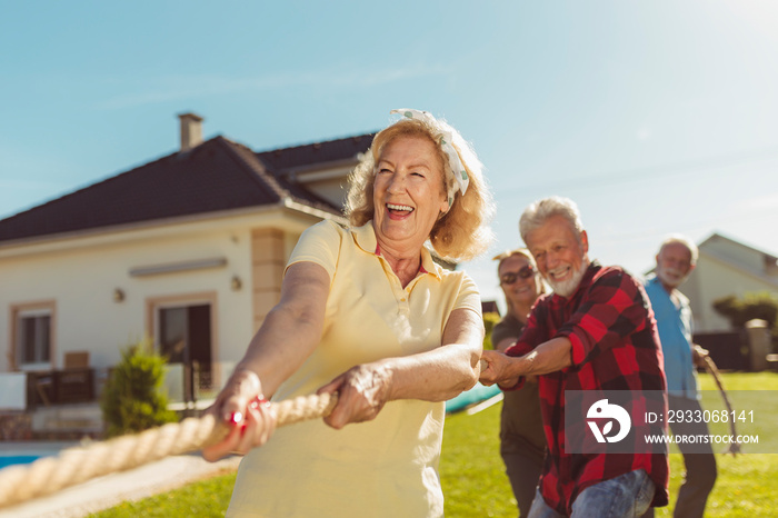 Elderly people having fun playing tug of war