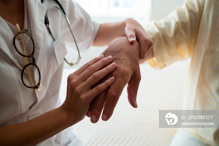 Midsection of doctor examining senior man in nursing home