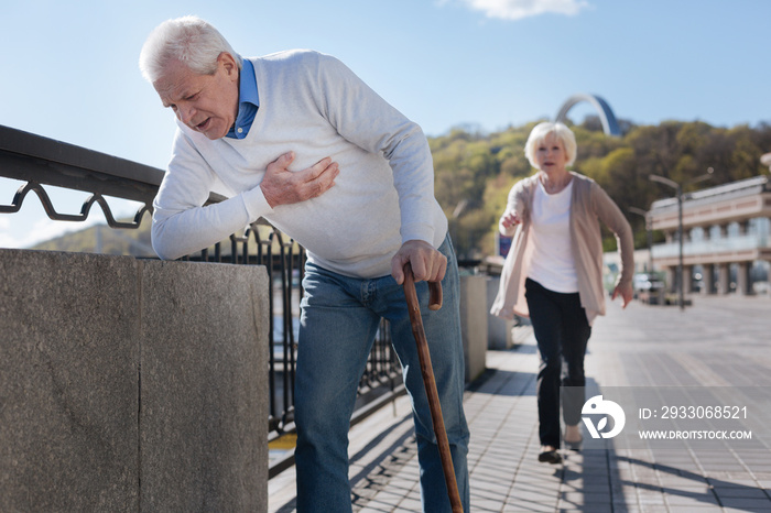 Aged pensioner having pain in his chest on the promenade