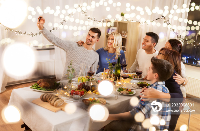 celebration, holidays and people concept - happy family having dinner party at home and taking selfie by smartphone