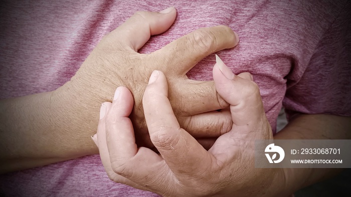 Man’s hand holding his chest