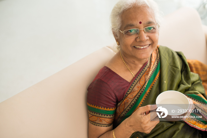 Aged woman enjoying tea