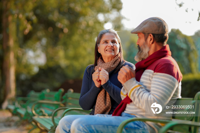 old couple in warm wear in winter at park