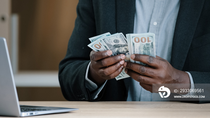 Close up African old male hands with money in office unrecognizable biracial success wealthy businessman holding dollars salary accounting savings budget cash financial income loan payment buying