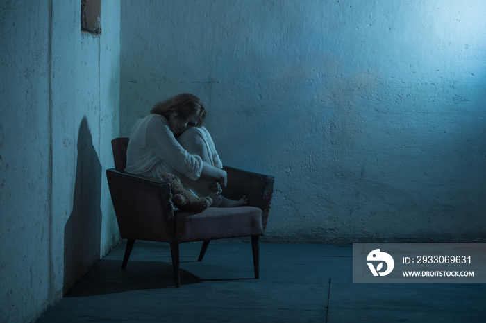 girl in white dress on old armchair  in basement