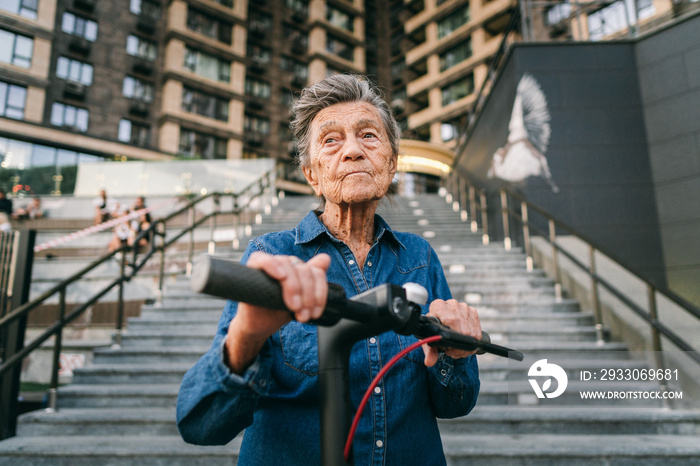 Active old woman riding electric scooter. Retired lady uses environmentally friendly city vehicle. Granny very old with gray hair, active and progressive. Modern senior woman use technology e scooter