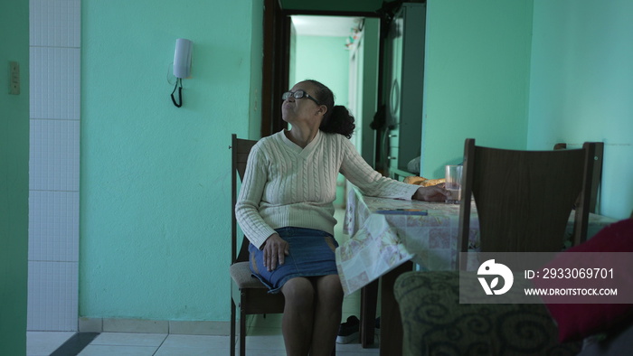 A thoughtful Senior black woman sitting a home alone. A pensive hispanic south american elderly person in living room