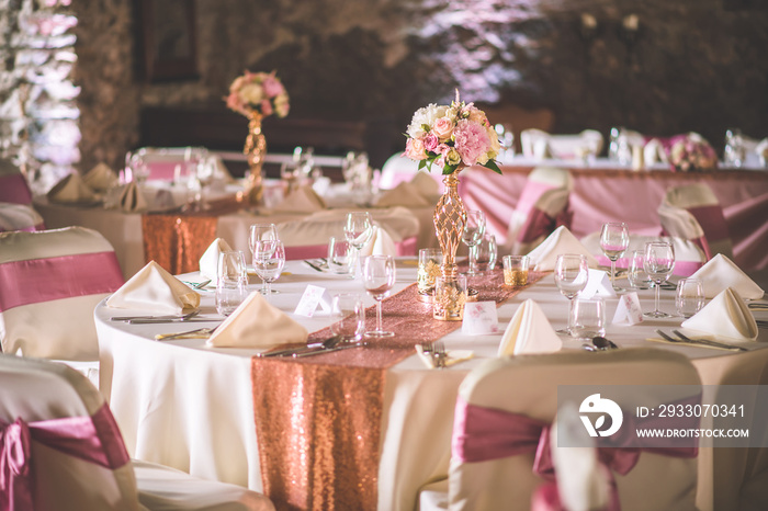 wedding table with exclusive floral arrangement prepared for reception, wedding or event centerpiece in rose gold colour