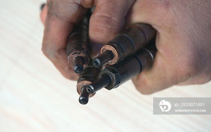 Old nozzles from a diesel car in the hands of a man