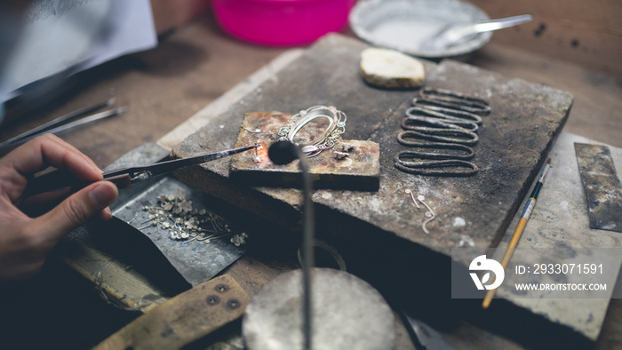 Jeweler at work in jewelry. Desktop for craft jewelry making with professional tools. Close up view of tools. Silver jewelry.