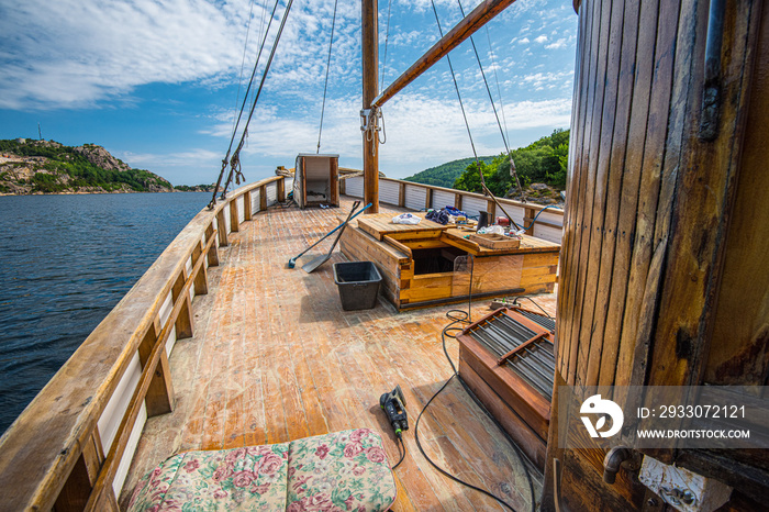 Deck of an old wooden fishing boat being sanded.