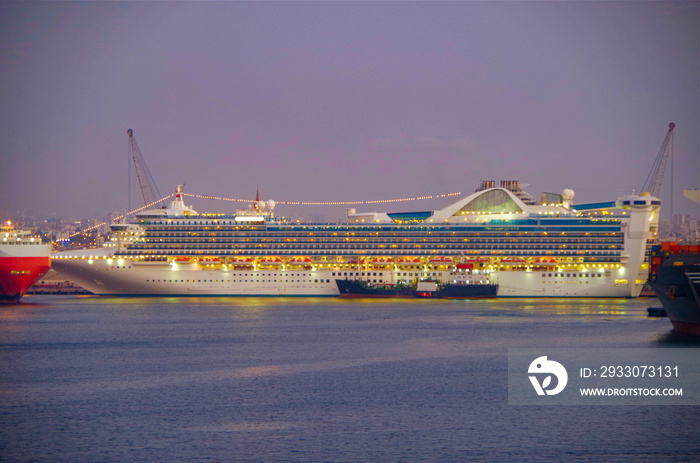 Modern Princess Cruises luxury cruise ship liner in the port of Callao, Lima during South America cruising with industrial harbor at night