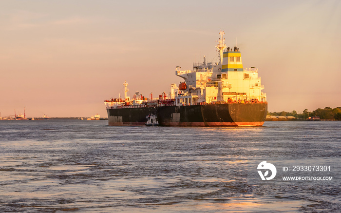 A big ship is traveling at Mississippi River under sunset