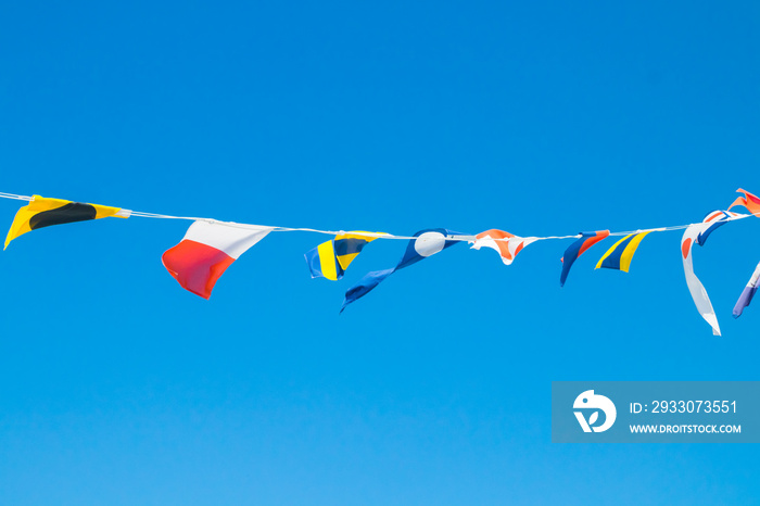 Nautical flags on the ship against blue sky