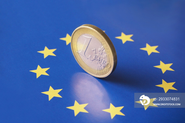 Closeup of a 1 euro coin on top of the European flag